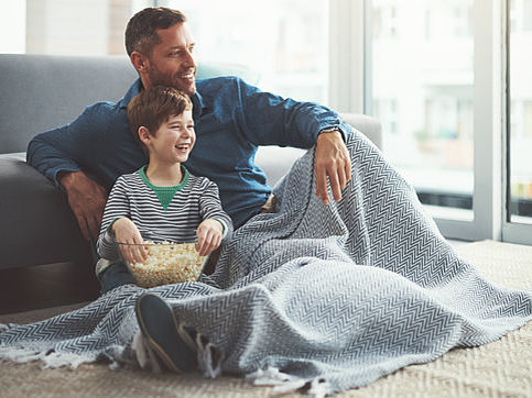 Father and son with popcorn watching TV