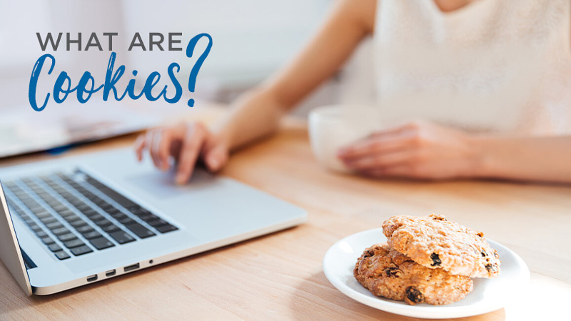 Woman on computer next to a plate of cookies